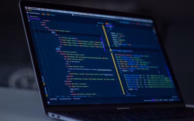 Laptop menampilkan kode WordPress dengan ikon gembok keamanan staging environment
