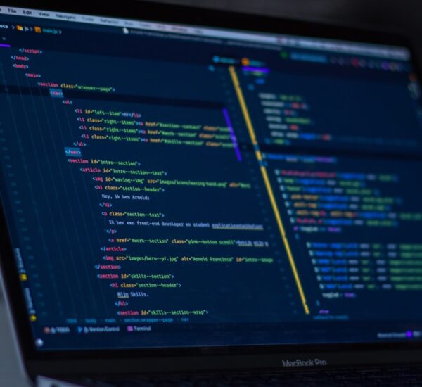 Developer reviewing WordPress plugin code on laptop screen for security patch management and vulnerability tracking